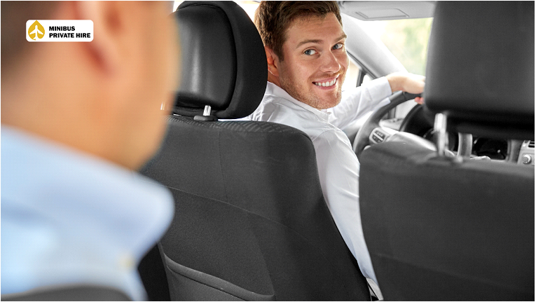 A taxi driver looking at passenger and smiling