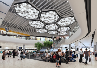 Manchester Airport terminal lounge with hexagon lights and passengers – Manchester Airport Taxi