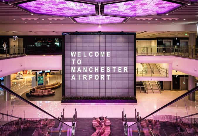 Welcome to Manchester Airport atrium with purple ceiling – Manchester Airport Taxi meet and greet