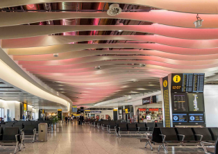 Heathrow Terminal hall with seating and signs – Heathrow Airport Taxi drop‑off