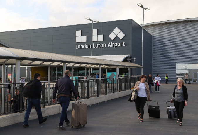 London Luton exterior London Luton Airport exterior with passengers and terminal sign - luton Airport Taxi pickups