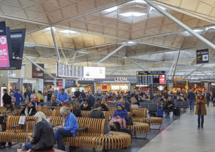 Busy departures lounge at London Stansted Airport with seating – book a Stansted Airport Taxi