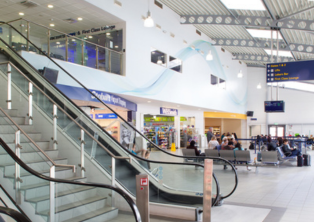 London Southend Airport terminal interior with escalators and signage